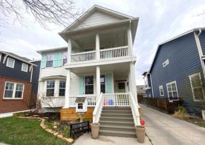 Image of exterior with white body and sky blue shutters and lime green door